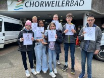 Sch&uuml;ler*innen halten Urkunde des Para-Schwimmens in die Kamera